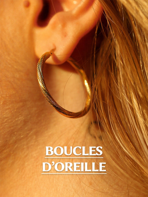 Boucle d'oreilles en or portée par une femme